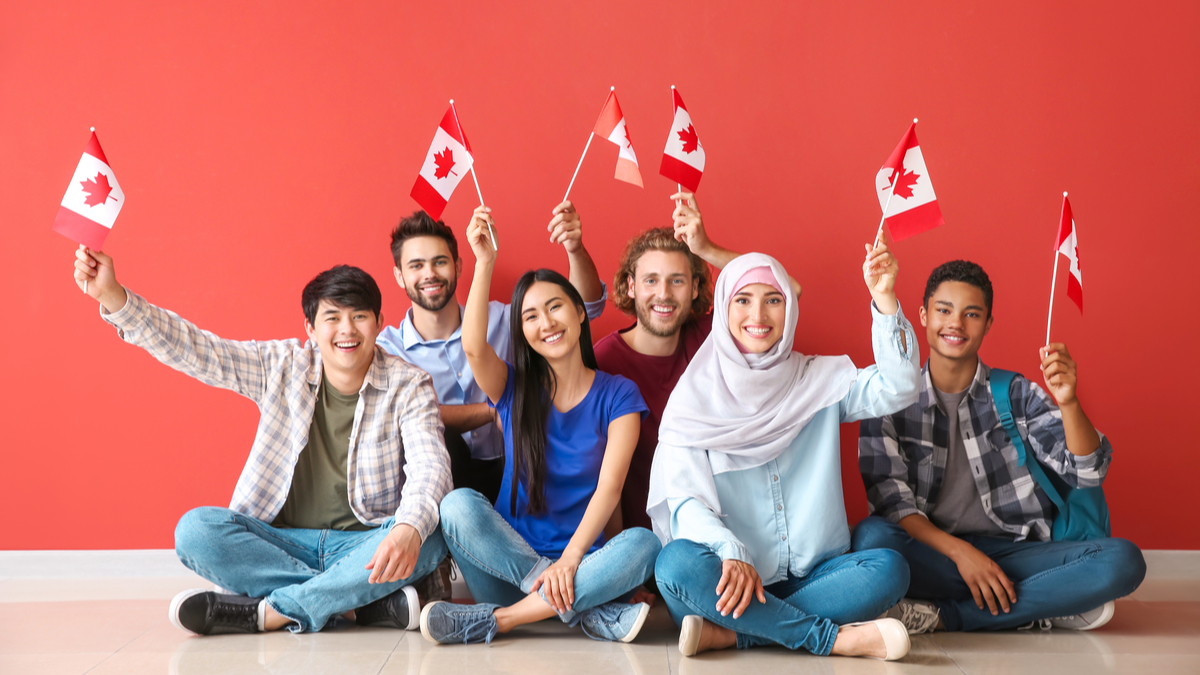 People wavings small Canadian flags | Immigrate to Canada from India in 2021