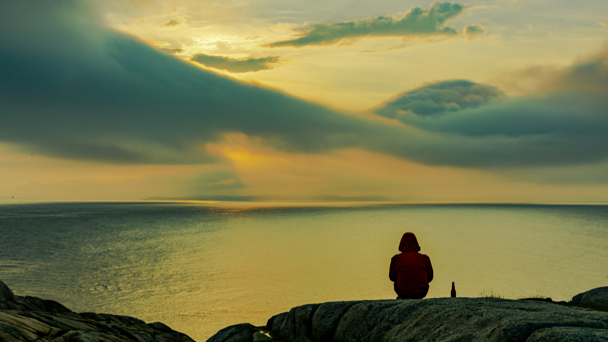 Person sitting down and overlooking lake in Canada